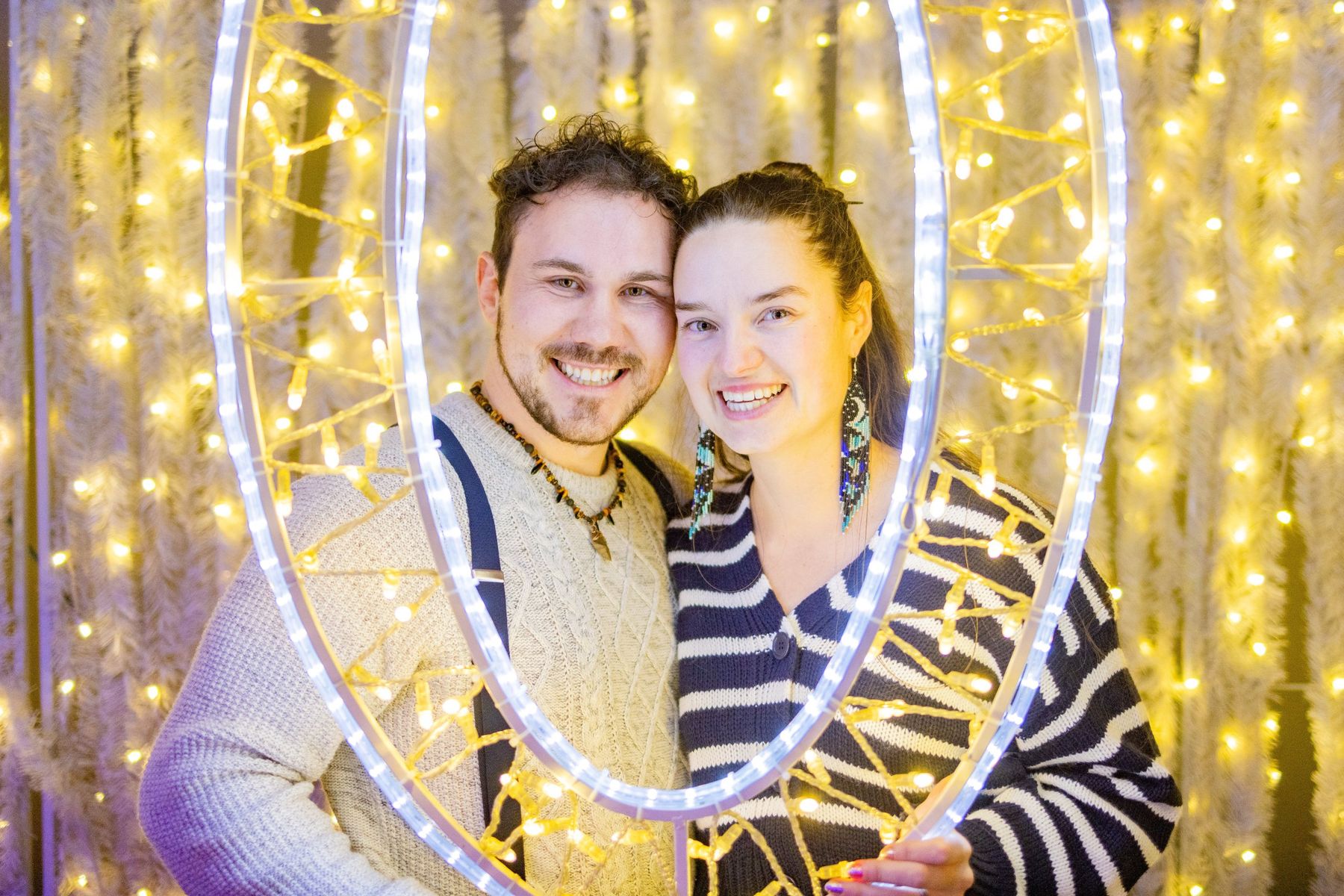 Ava and Bran smiling together inside a glowing ring of lights