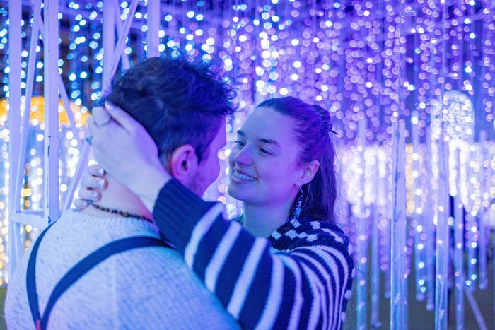 Ava smiling as Bran leans in, bathed in blue and purple light