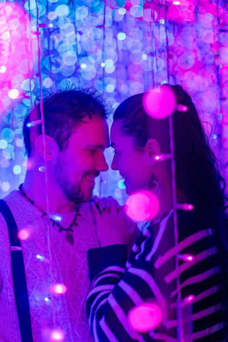 Ava and Bran forehead to forehead in pink light