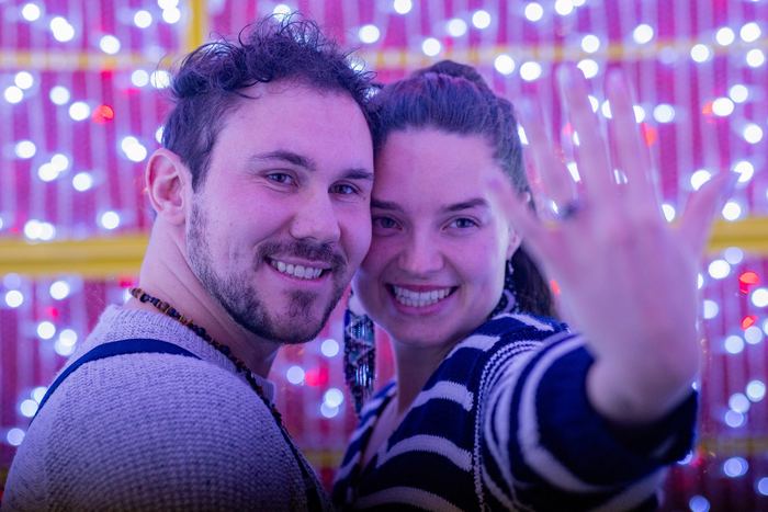 Ava and Bran cheek to cheek with her ring hand held up to the camera